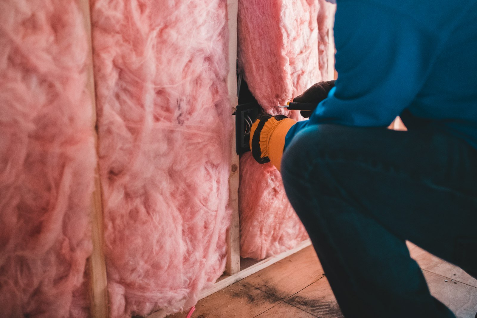 Insulation contractor installing fiberglass wall insulation in a Toledo, OH home